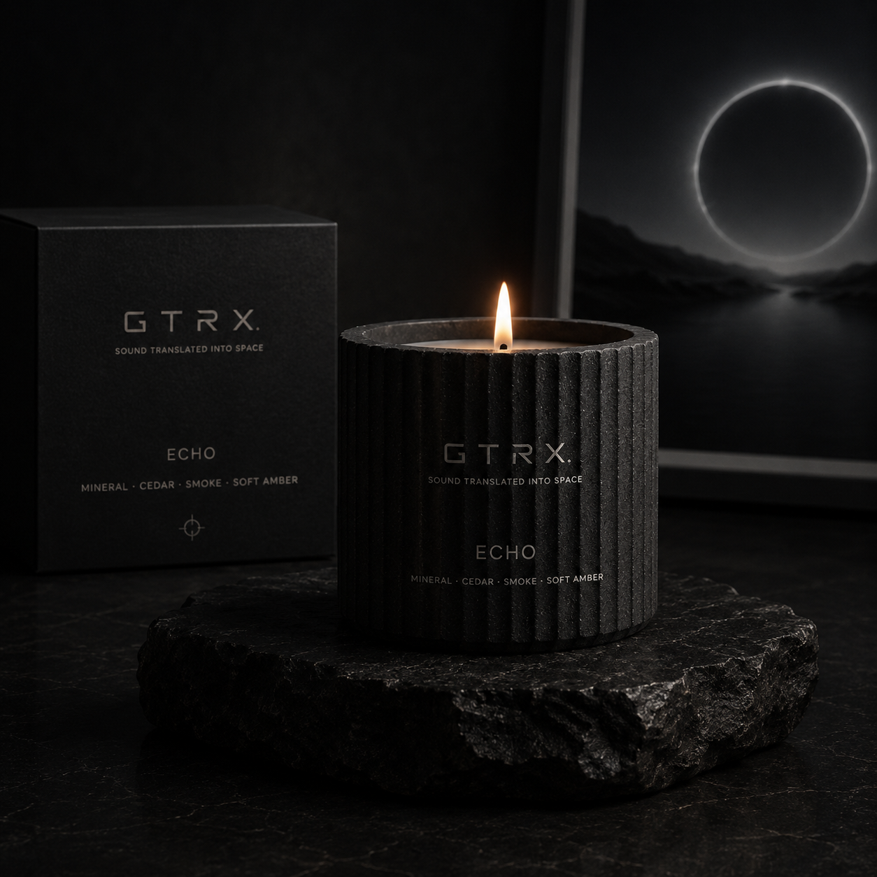 GTRX Echo candle in a fluted black vessel, lit, resting on volcanic rock